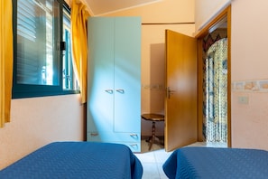 A room with two beds, a wardrobe, a small table, and a door leading to another room. - Villa 'Fronte Mare Liolà - 4 guests' with Sea View, Private Beach Access (Scicli)