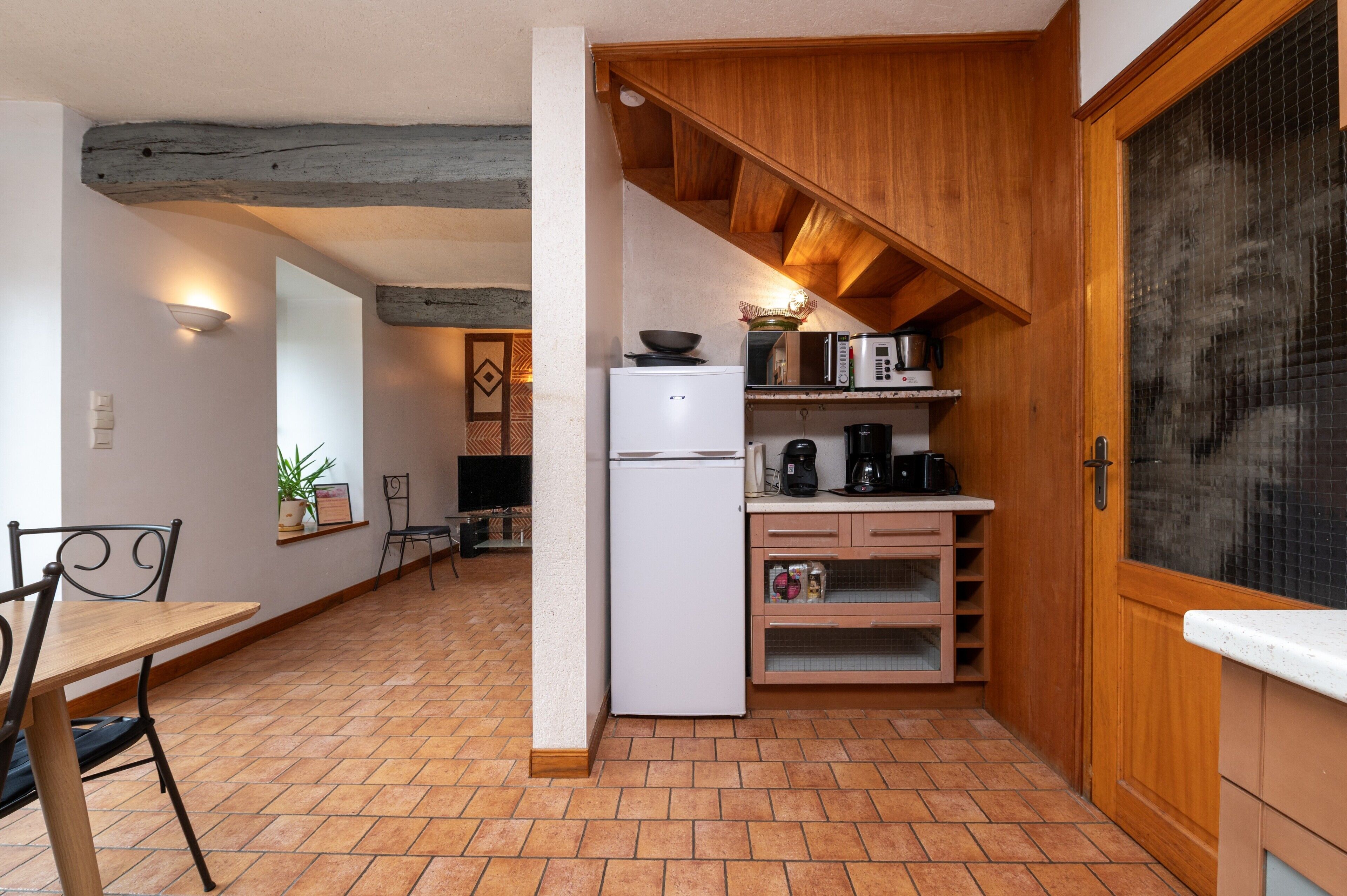 A compact kitchen with a refrigerator, microwave, and coffee maker.