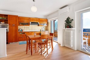 Moderni keittiö, jossa on puiset kaapit, ruokapöytä ja tuolit.
