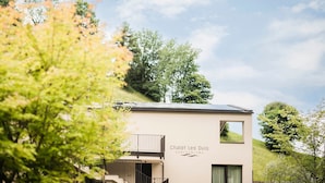 Een modern gebouw met een bordje 'Chalet Les Ovis AGRITURISMO' en een balkon.