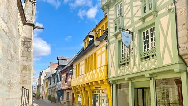 A narrow street lined with traditional half-timbered buildings, some with signage indicating businesses. - Holiday Home Gîte La Colombe - Les Hortensias (La Croix-Helléan)