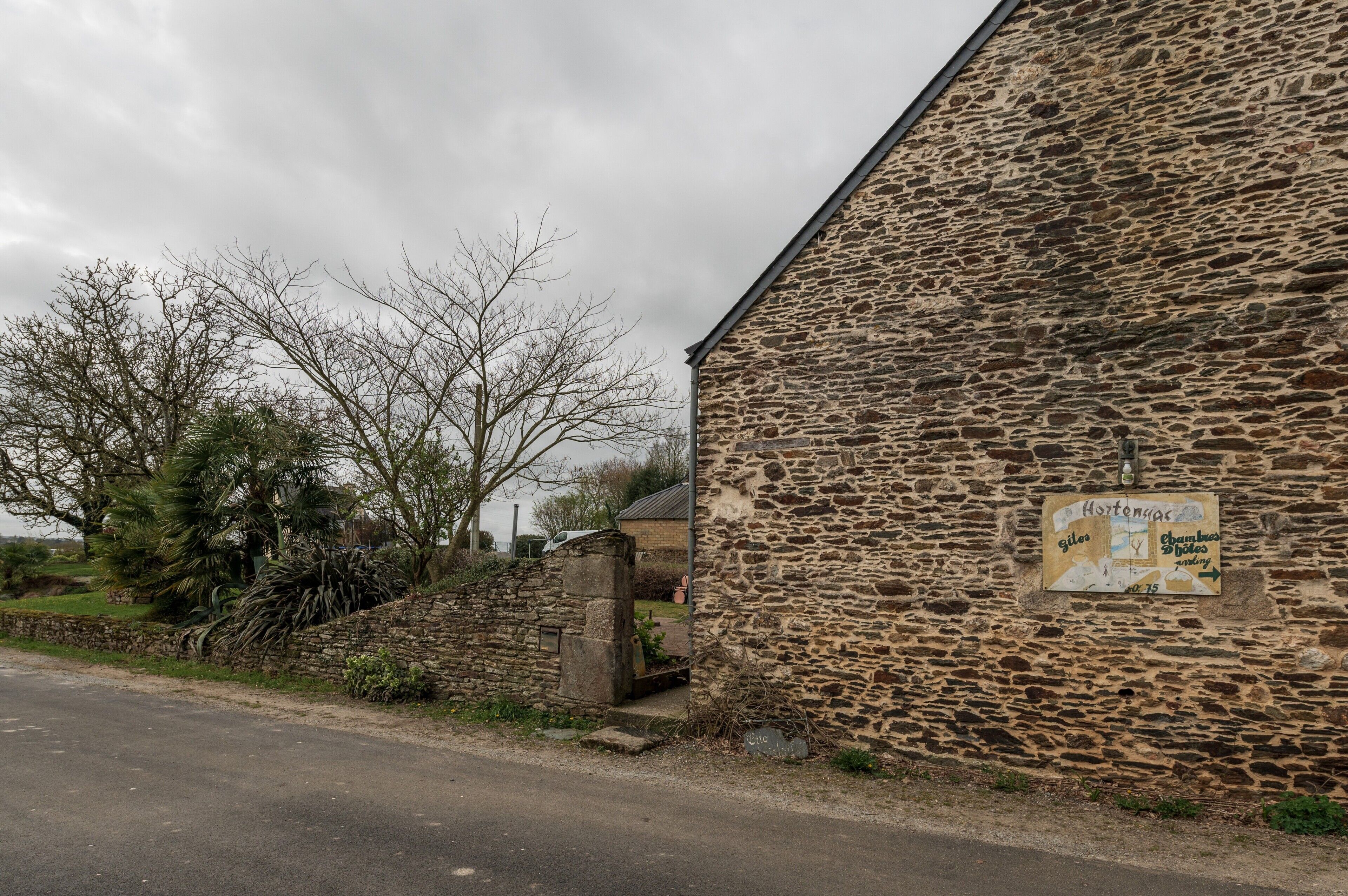 A stone building with a sign indicating directions to 'giles' and 'Chambers'.