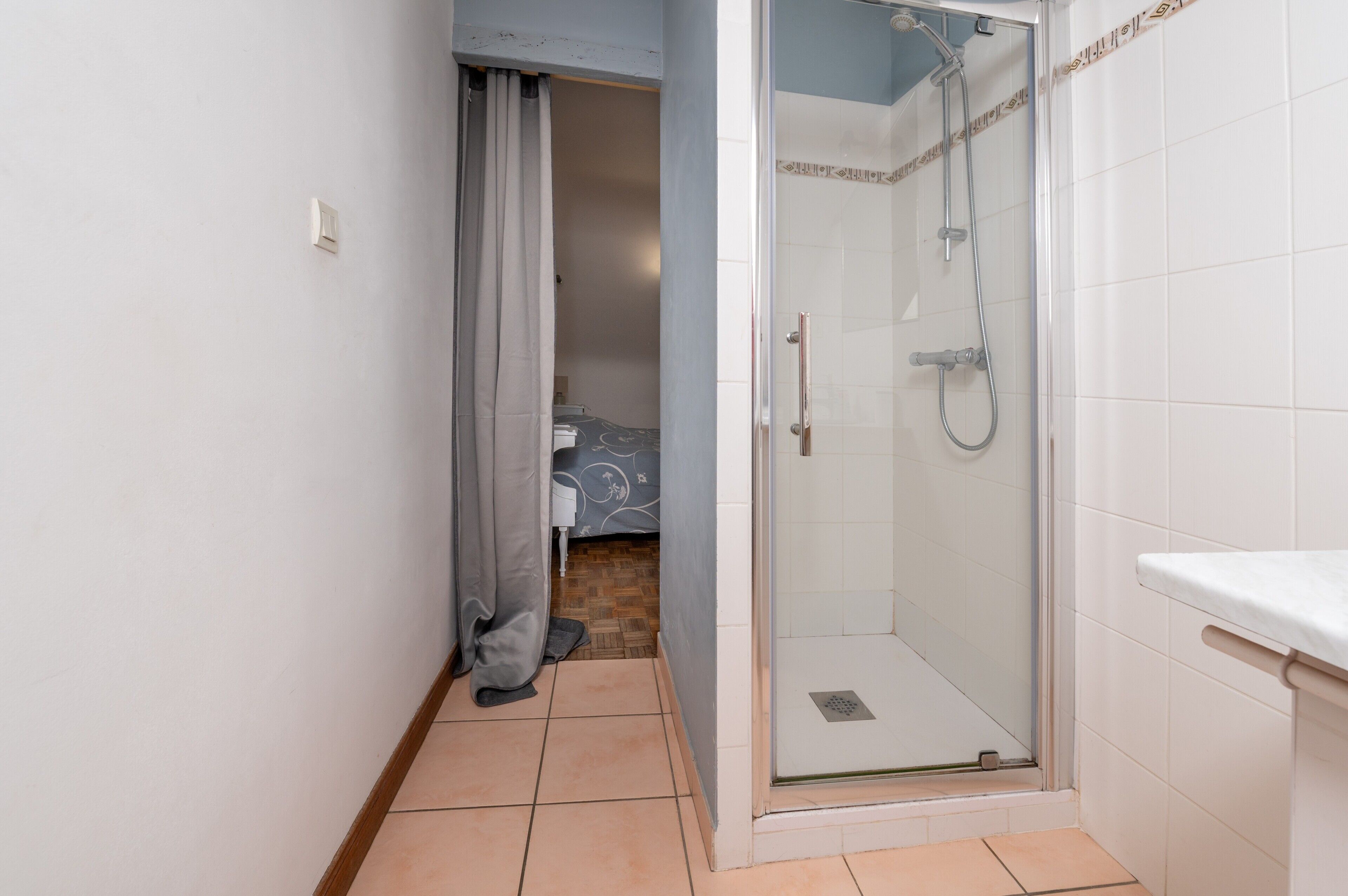 Et badeværelse med bruser, toilet og håndvask.