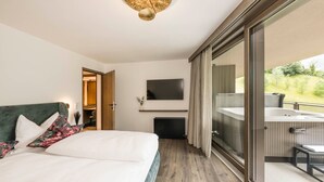 A hotel room with a bed, a TV, a bathroom with a shower, and a balcony with a view. - Apartment 'Les Ovis Comisana' – Opening May 2026 with Private Jacuzzi (San Leonardo in Passiria)