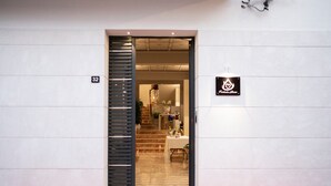 Een hotelentree met een modern design, een zichtbare trap en een bord met de naam van het hotel.