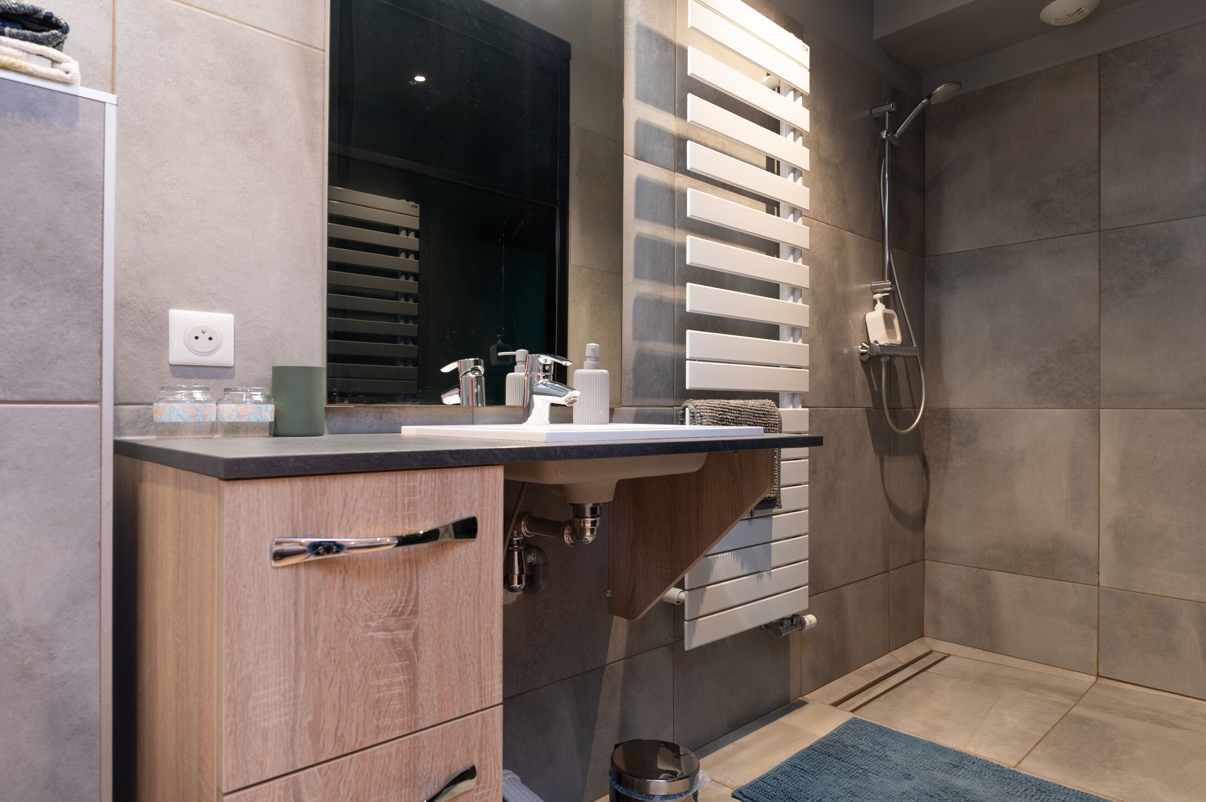 Une salle de bain moderne avec un lavabo, un miroir et une douche.