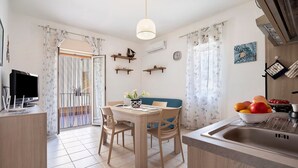 A compact kitchen with a dining table, chairs, a hanging light fixture, and a sink. - Casa Jessica – Your Stay Between the Sea, Relaxation, and Authentic Sicily (Balestrate)