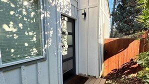 A house with a front door, a small porch, and a wooden fence.