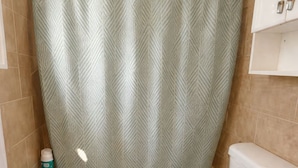 A bathroom with a bathtub, toilet, and a shower curtain. - Miami Beach Escape Delightful 1 Bedroom  (Miami Beach)