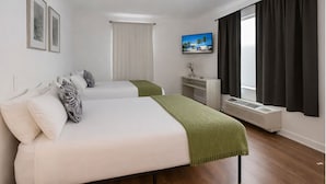 A hotel room with two beds, a TV, a desk, and a window with curtains. - Miami Beach Escape Delightful 1 Bedroom  (Miami Beach)