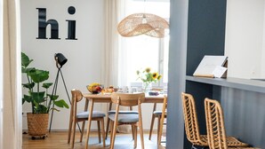 A modern dining area with a wooden table, chairs, and a potted plant. - Soluna Stay | Lucerne | Mountains | Lake | Family-Friendly | Pilatus & Rigi View (Küssnacht)