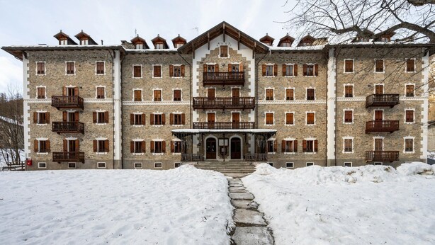 Un edificio de piedra grande con varios balcones y una entrada central.