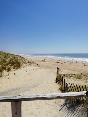 A beach with a wooden fence, sandy dunes, and the ocean in the background. - In the heart of the village, 70 m2 Landes house ideal for a family of 4 people (Léon)
