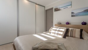 Ein Schlafzimmer mit einem Bett, einer Schiebetür und zwei Bildern an der Wand.