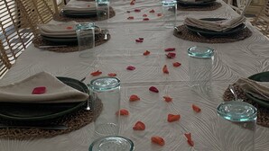 Une table à manger dressée pour un repas, avec vue sur l’extérieur.