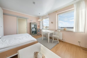 A bedroom with a bed, a desk, and a window. - Cozy 1-room apartment in Hörnum - close to the beach & budget-friendly - (Hörnum (Sylt))