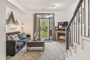 Una sala de estar con sofá, mesa de centro y chimenea.