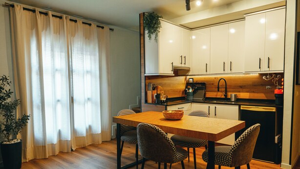 A modern kitchen with wooden cabinets, a dining table with chairs, and a potted plant. - Duplex with wonderful views, next to the historic center and walking trails. (Cazorla)
