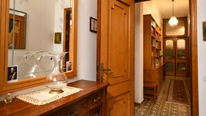 A wooden dresser with a glass pitcher, a mirror, and a lace doily. - Apartment for 4 in Quartu, near Poetto, Cagliari and nature, comfortable and complete (Quartu Sant'Elena)
