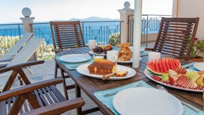 A table set for breakfast with a view of the sea, including plates with food and drinks. - Villa Anthula mit Pool und herrlichem Meerblick by Interhome (Kalami)