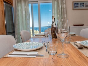 A dining table set with plates, glasses, and cutlery, overlooking a scenic view. - Villa Anthula mit Pool und herrlichem Meerblick by Interhome (Kalami)