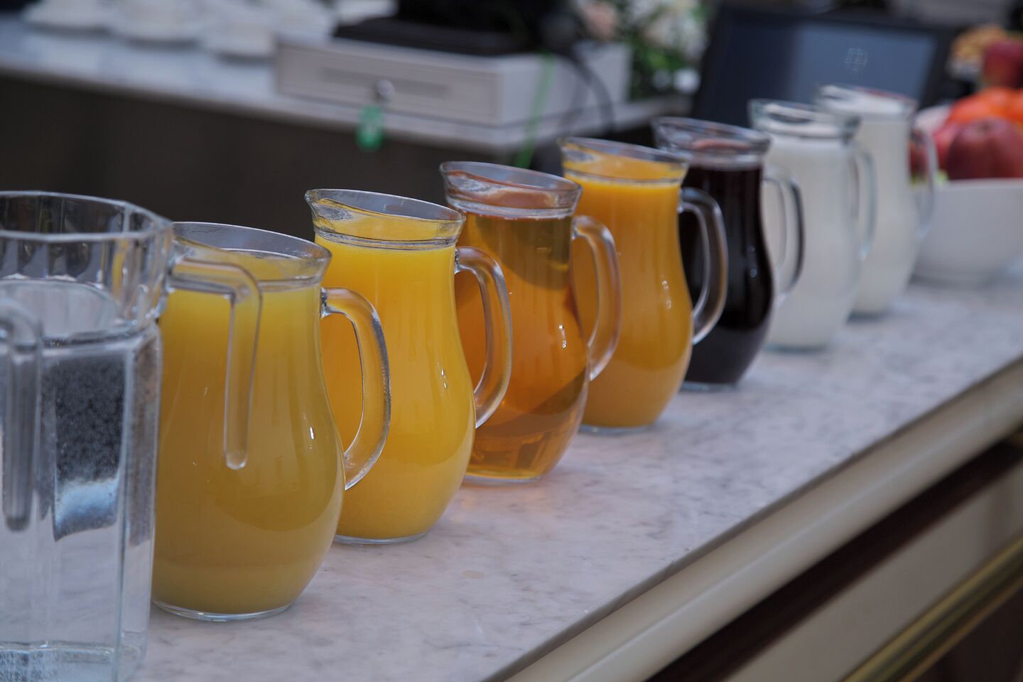 Un bar où l’on sert le petit-déjeuner, avec un choix varié de boissons, notamment du jus d’orange et du café.