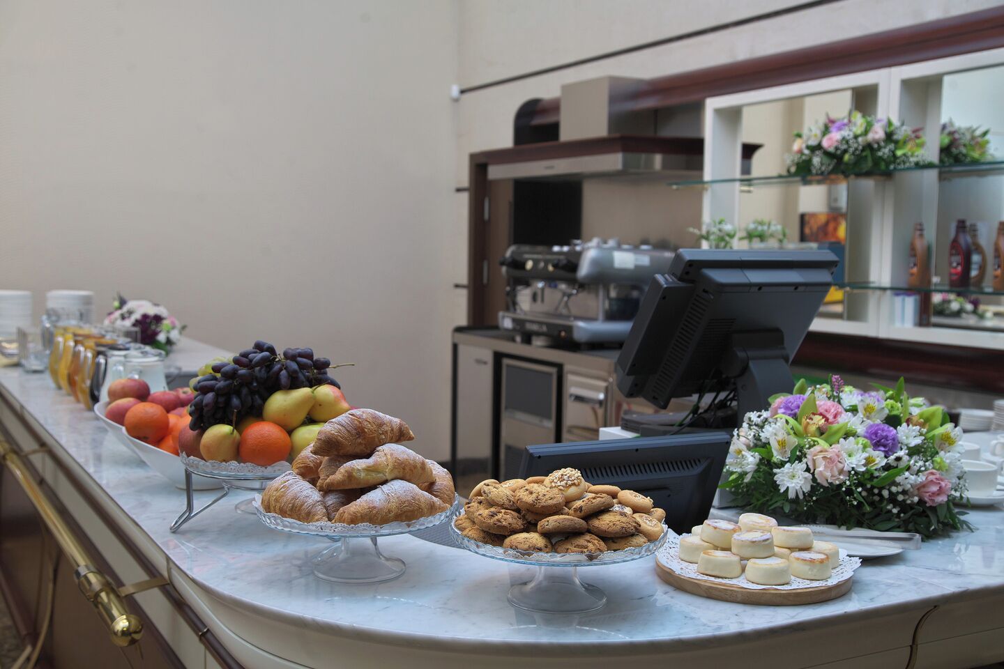 En buffet med forskellige kager, frugter og blomster.