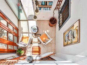 A sunlit reading nook with a wooden bench, a small table, and a potted plant. - Villa mit Meerblick und privatem Pool by Interhome (Kalkan)