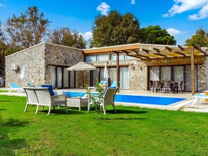 A stone building with a pool, outdoor seating, and a covered patio area. - Steinhaus in Fethiye Kayaköy by Interhome (Ölüdeniz)