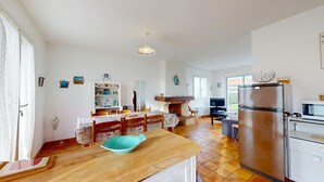 Una cocina amplia con una mesa de comedor de madera, estufa integrada y refrigerador.