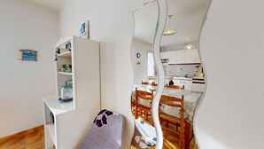 Un espacio habitable compacto con kitchenette, comedor y una pequeña zona de estar.