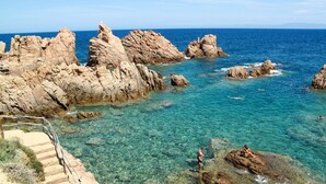 A coastal landscape with rocky formations and clear blue waters. - 'Rosa 4 by Interhome (Costa Paradiso)