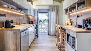 A modern kitchen with wooden cabinetry, a built-in oven, and a coffee station. - Villa Pine Trees bei Kardous, Skopelos Privater Pool by Interhome (Skopelos)