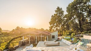 A stone patio with outdoor seating, a small building, and a view of the surrounding landscape. - Villa Pine Trees bei Kardous, Skopelos Privater Pool by Interhome (Skopelos)