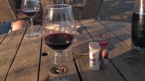 Taula de fusta amb copes de vi i ampolles d'assaisonament.