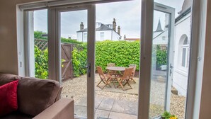Ein Zimmer mit einer Schiebetür zu einer Terrasse im Freien, komplett mit Tisch und Stühlen.