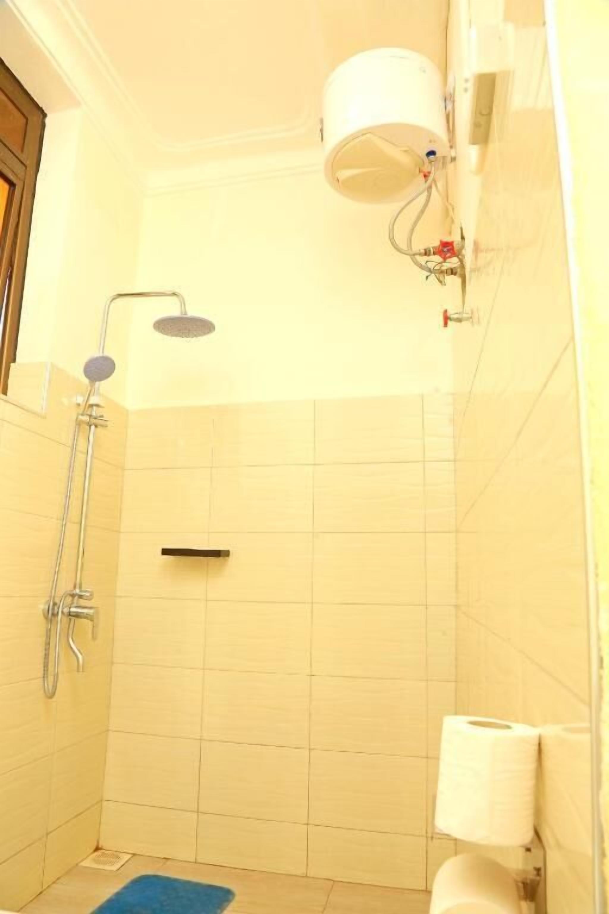 Un baño pequeño con ducha, inodoro y un perchero para toallas.
