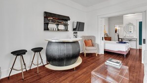 Una camera moderna con un tavolo bar rotondo, un letto, una sedia e un televisore a parete.