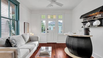 Un salon comprenant un canapé, une table basse et une table ronde originale aux motifs noir et blanc.