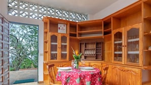 A dining area with a table set for two, wooden cabinets, and a view of trees outside. - "El pajal House Relax" by Interhome (Santa Ursula)