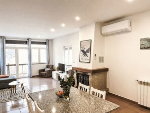 A modern living room with a fireplace, dining table, and comfortable seating. - Casa de Casarelhos by Interhome (Covas)