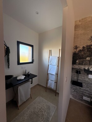A bathroom with a sink, mirror, towel rack, and a window. - New 80 m² apartment with private garden - Lozari sea view - 6 pers. (Belgodere)