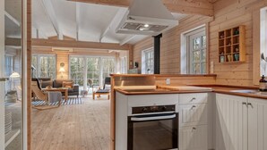 A modern kitchen with white cabinets, a built-in oven, and a wooden countertop. - "Landrich" -  from the sea by Interhome (Hadsund)