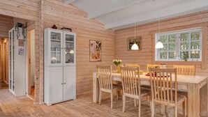 A wooden interior with a dining area, white cabinets, and a window with a view. - "Landrich" -  from the sea by Interhome (Hadsund)