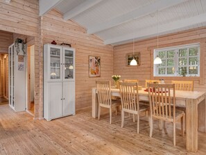A wooden interior with a dining area, white cabinets, and a window with a view. - "Landrich" -  from the sea by Interhome (Hadsund)