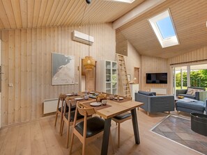 A wooden interior with a dining table, chairs, a sofa, a TV, and a map on the wall. - "Yorick" - 350m to the fjord by Interhome (Tarm)