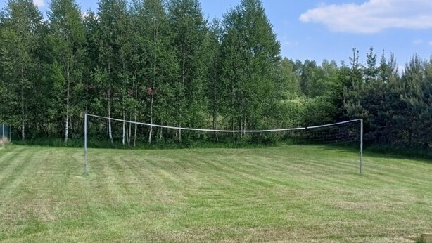 Ein grünes Feld mit einem Volleyballnetz.