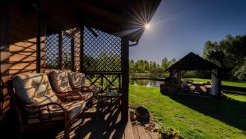 A wooden deck with wicker furniture and a gazebo.