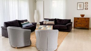 A modern living room with a grey sofa set, a coffee table, and a wooden dresser.