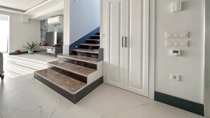 A modern interior with a staircase, a large wardrobe, and a wall-mounted thermostat. - Luxuriöse Villa "Galaxy V3", 300 Meter vom Meer by Interhome (Ölüdeniz)